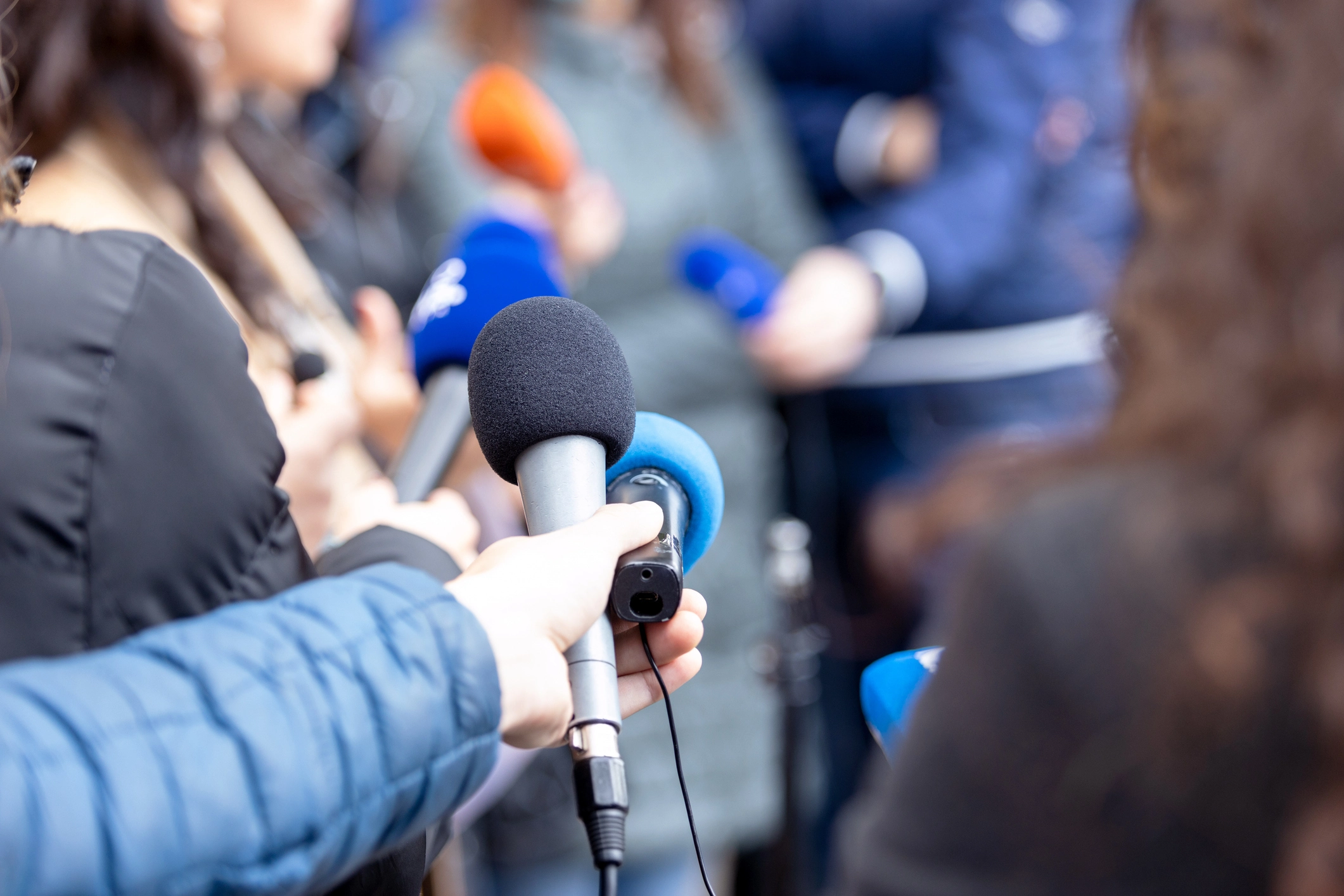 Press scrum with microphones